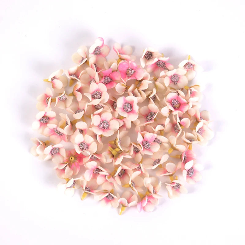 A cluster of small, light pink and cream silk artificial flower heads used for weddings, crafts, or home decor.
