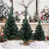 A festive display of plush faux fur Christmas trees in various shades of green and white.