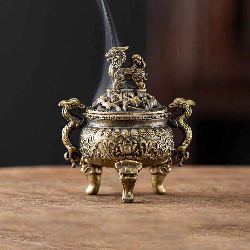 A vintage brass incense burner holder with a lion motif is shown on a wooden surface.