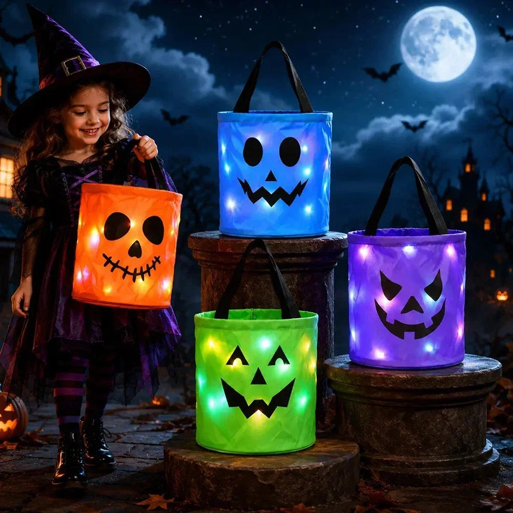 A young girl in a witch costume stands next to three glowing LED illuminated trick-or-treat bags of different colors against 
