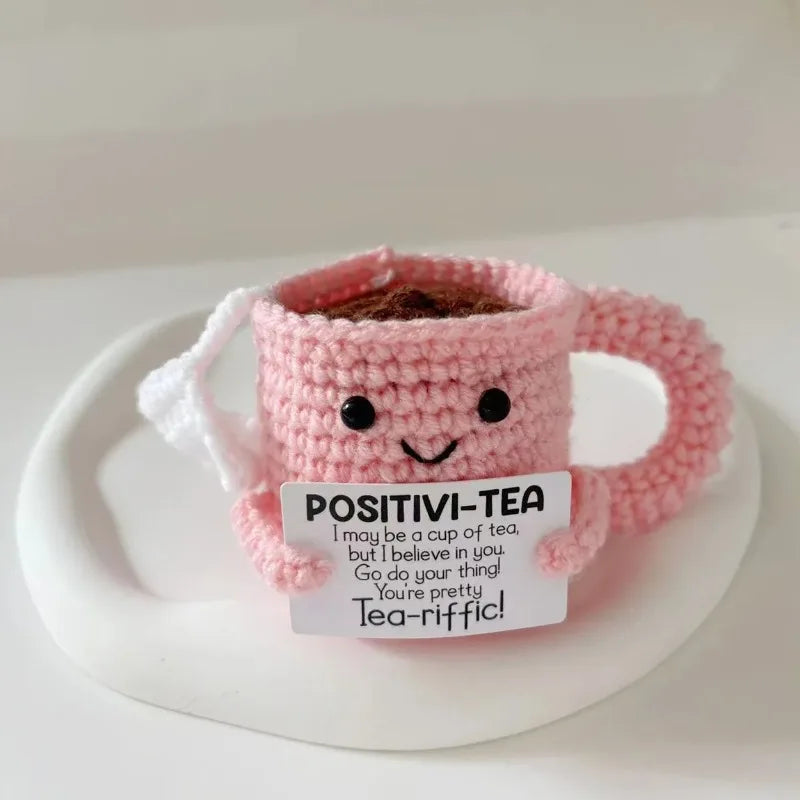 Handmade crochet pink tea cup ornament with a brown tea bag charm and motivational text