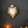 A golden flame sacred heart wall pendant with a resin finish mounted on a dark wall.