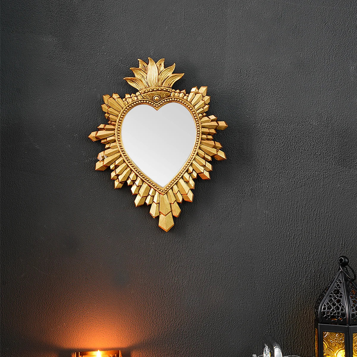 A golden flame sacred heart wall pendant with a resin finish mounted on a dark wall.