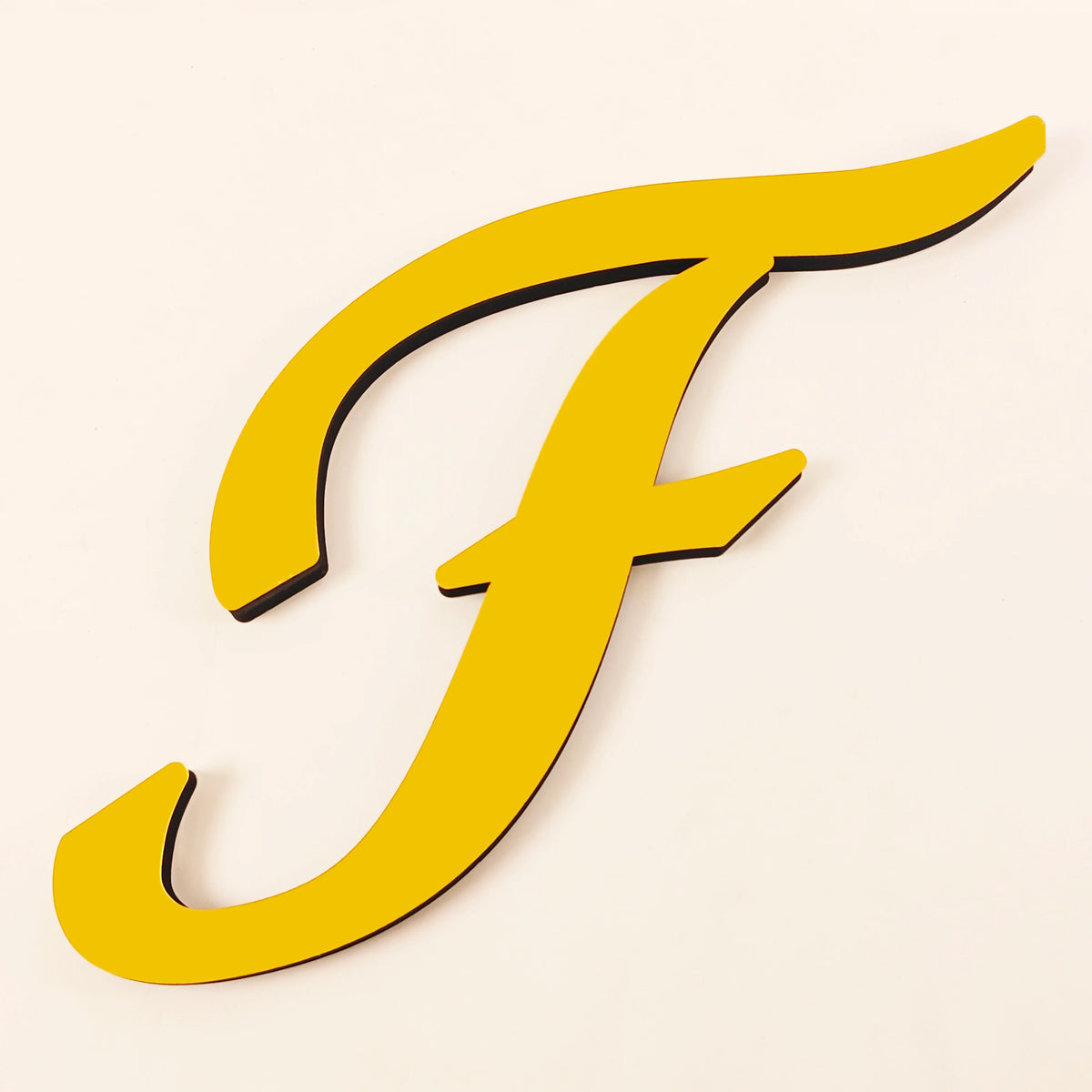 A gold 3D acrylic letter F wall sticker with a smooth, curved design.