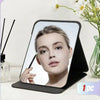 A portable foldable vanity mirror with an adjustable stand showing a woman's face.