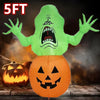 A lime green inflatable monster decoration with a screaming face stands above an orange pumpkin.