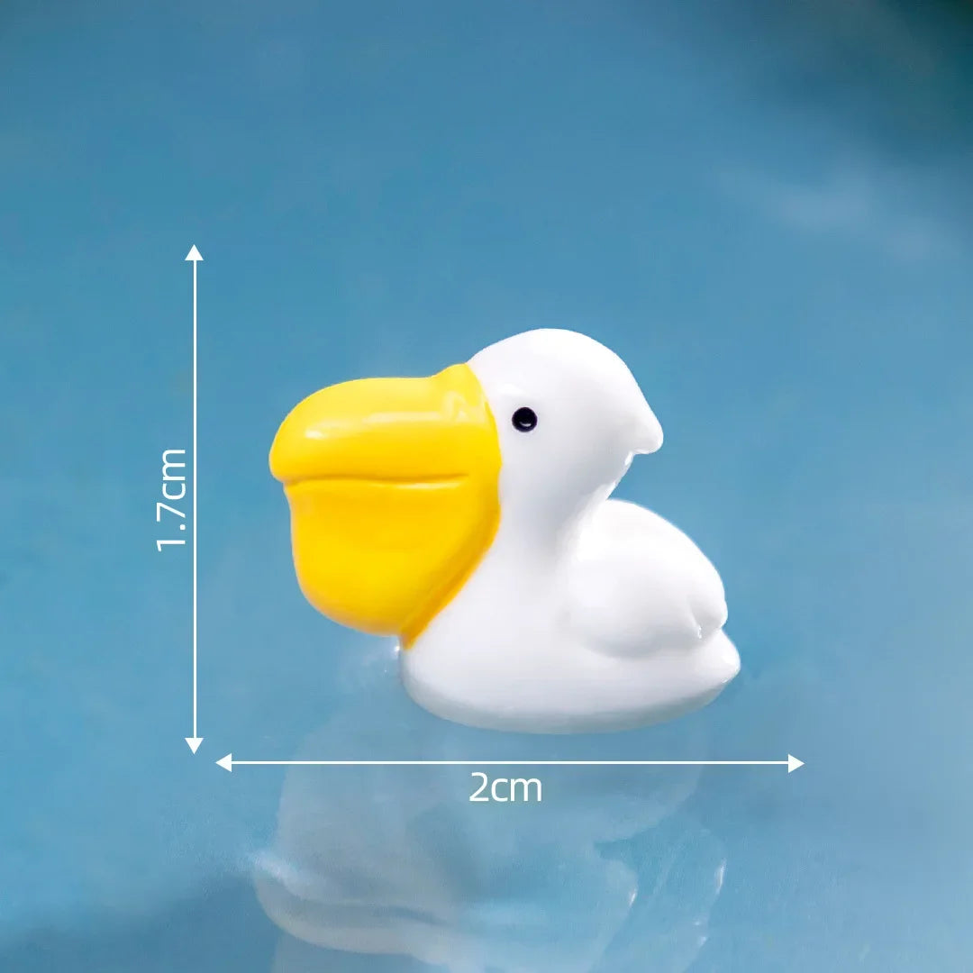 Sculpture en résine blanche d'un canard à bec jaune, sur fond bleu.