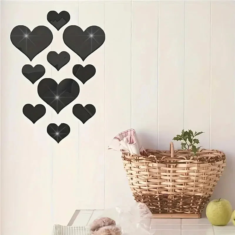 A set of black heart-shaped mirror wall stickers displayed against a white paneled wall.