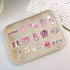 A collection of pink bow nurse graffiti stickers featuring clothing, medical items, and nurse graphics on a light tray.