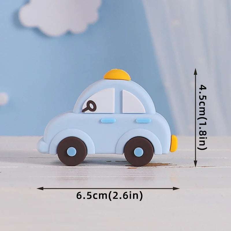 Light blue baby block car topper with a yellow roof and a key detail, shown on a white surface.