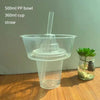 A clear plastic bowl with a straw is shown next to a small glass jar containing green leaves.