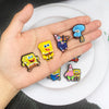 A hand holds a set of SpongeBob SquarePants shoe charms featuring various characters like SpongeBob and Patrick.