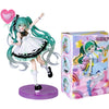 A PVC collectible figurine of Hatsune Miku in a light blue dress and green hair, standing on a purple base.