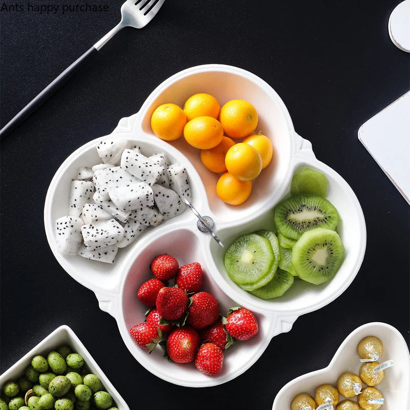 Weiße Keramik-Servierplatte gefüllt mit frischen Snacks wie Zitrusfrüchten, Kiwi und Erdbeeren.