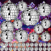 A collection of silver mirror balls of various sizes and shapes hanging against a colorful, sparkling background.