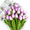 A bouquet of artificial pink and purple tulips with green stems and leaves.