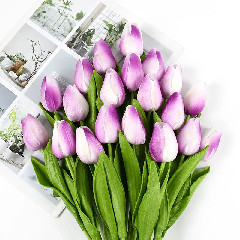 A bouquet of artificial pink and purple tulips with green stems and leaves.