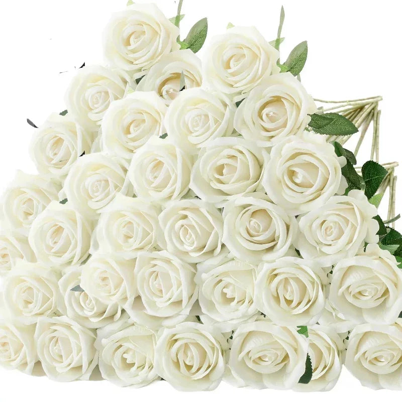 A bouquet of white artificial roses with green leaves.