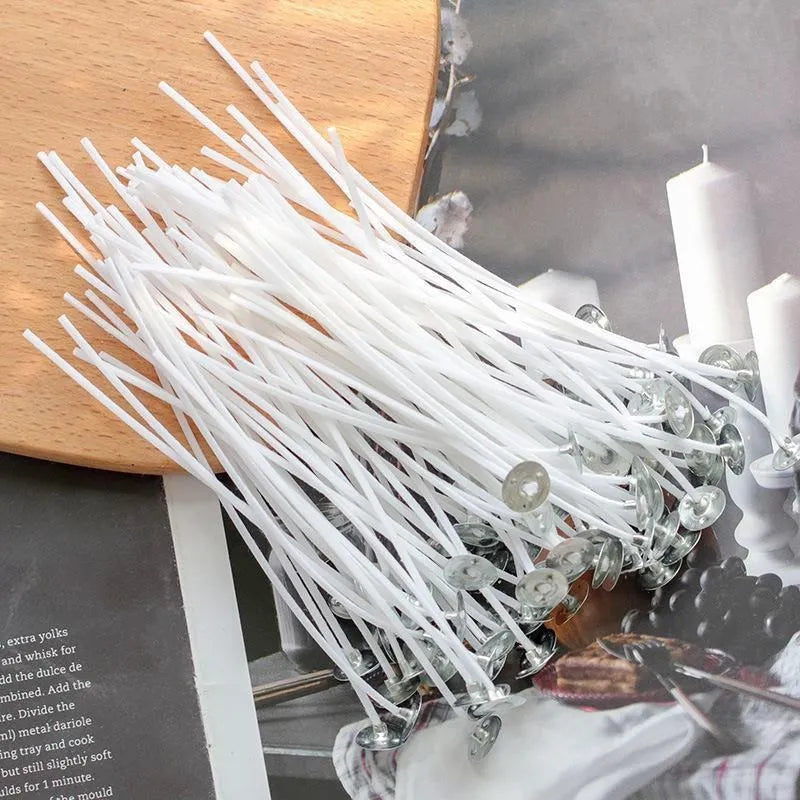 A bundle of white smokeless cotton candle wicks is displayed on a wooden surface.
