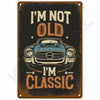 A vintage retro metal wall sign with distressed orange and black text that reads I'm not old I'm classic above a stylized car