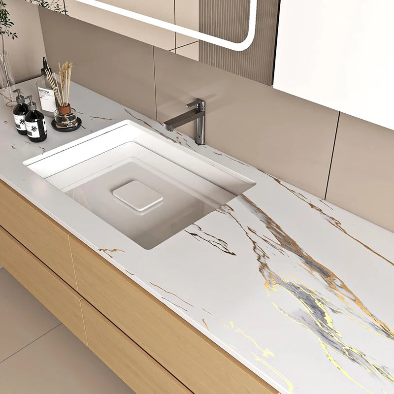 A modern bathroom vanity featuring a white marble countertop and sink with gold veining.