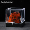 A reddish-brown obsidian rough stone specimen displayed inside a clear glass box.