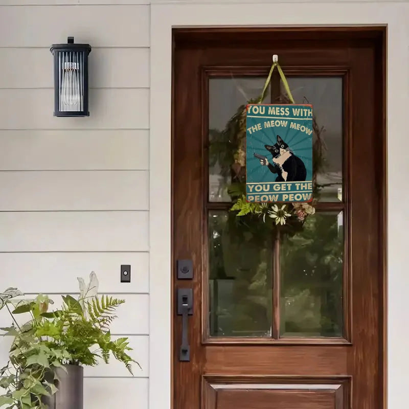 Puerta de madera con paneles de vidrio decorada con un letrero que dice 'You mess with the meow meow You get the peow peow'
