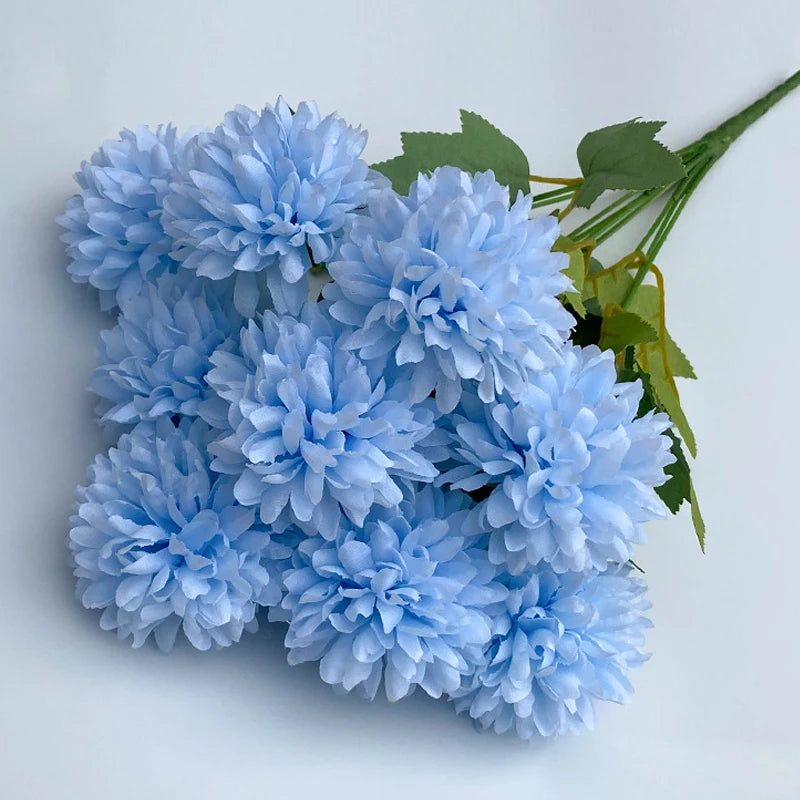 A bouquet of artificial light blue hydrangea and green camellia flowers.