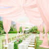 Pink sheer chiffon curtains draping an outdoor wedding reception area with a long table setup.