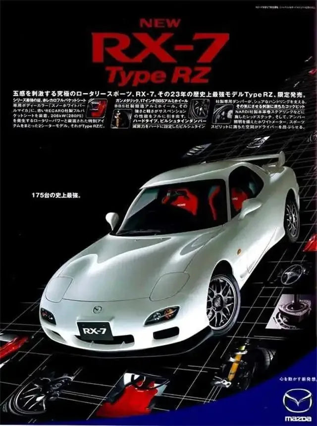 A white Mazda RX-7 sports car model displayed on a black surface with various parts and accessories below.