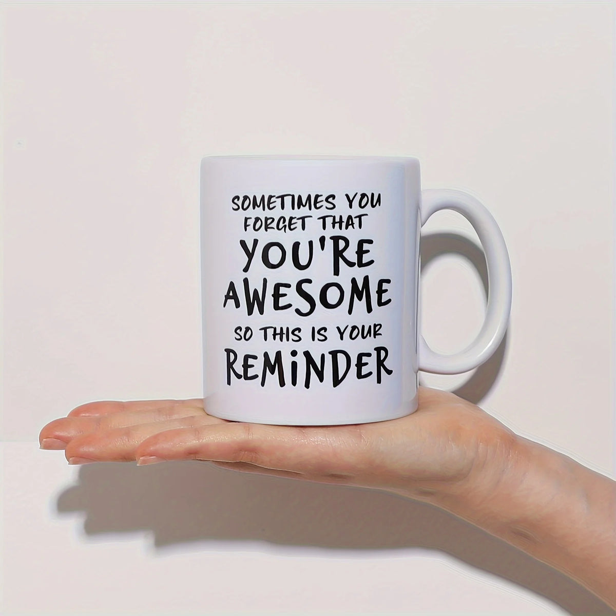 A white ceramic coffee mug with black text that reads Sometimes you forget that you're awesome so this is your reminder