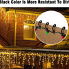Close-up of black color paint resisting dirt on a brick wall, with outdoor string lights visible.