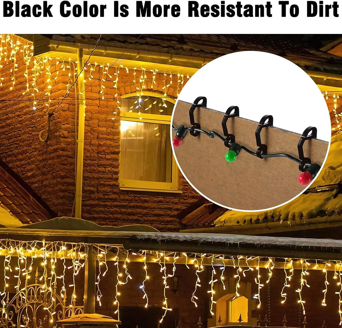 Close-up of black color paint resisting dirt on a brick wall, with outdoor string lights visible.