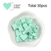A white dish filled with 30 light green silicone heart beads for DIY jewelry making