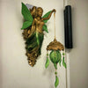 A vintage bronze-finished resin sculpture of a mermaid with green leaves and a hanging lamp.