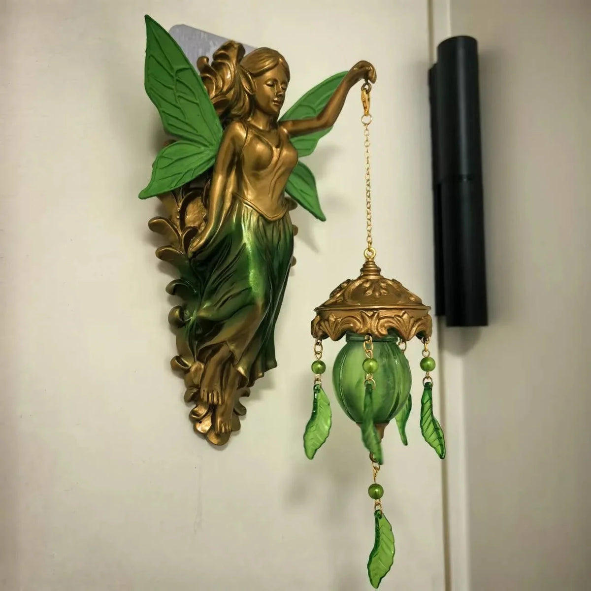 A vintage bronze-finished resin sculpture of a mermaid with green leaves and a hanging lamp.