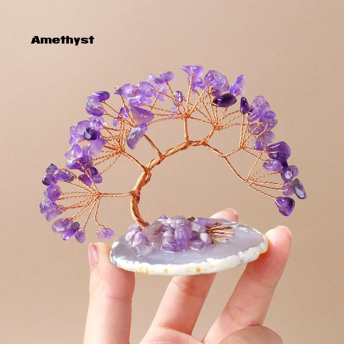 A natural amethyst crystal tree with purple clusters on a white agate base.