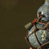 A dark blue ceramic wine gourd tied with brown twine and featuring gold-colored decorative elements.