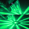 A hand holds a clear LED side marker light, shining bright green beams across a dark background.