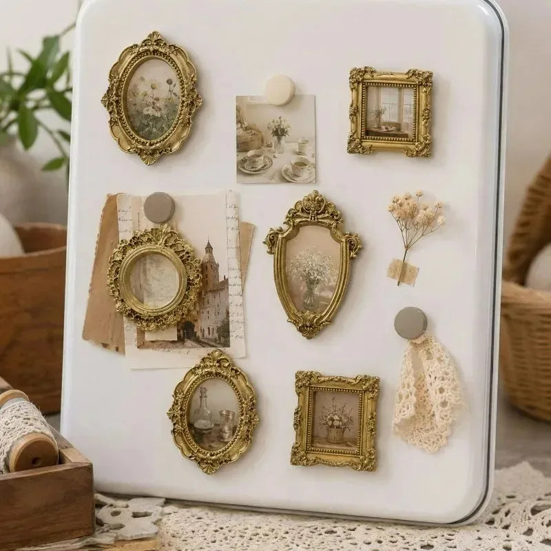 A white tray displaying a set of vintage gold-framed resin mini photo frames for crafting and display.