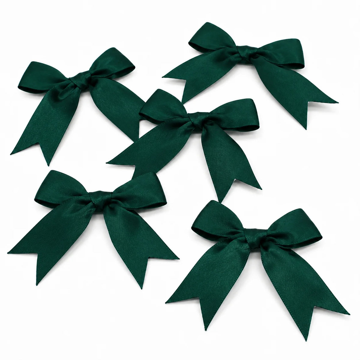 A collection of dark emerald green satin ribbon bows for gifts and DIY crafts.