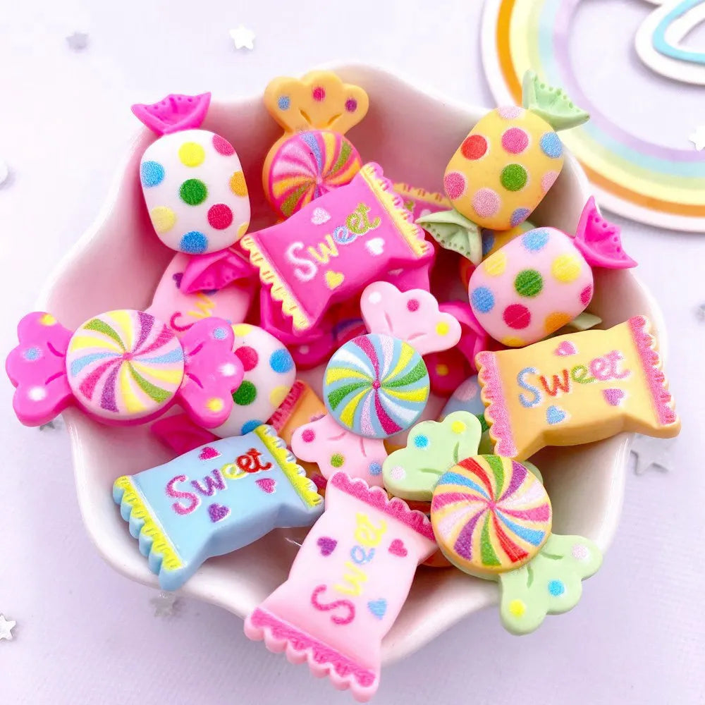 A pink bowl filled with colorful candy resin cabochons in various shapes and colors for crafting projects.