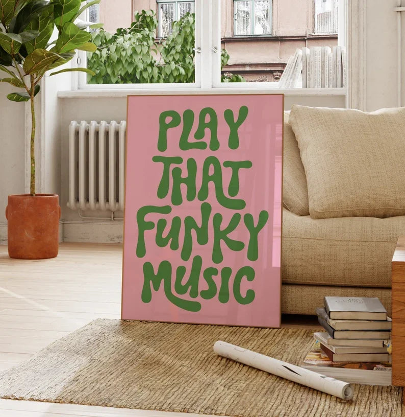 A pink canvas art poster featuring green text that reads PLAY THAT FUNKY MUSIC, displayed indoors.