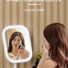 A woman is using an LED cosmetic mirror for makeup, showing a close-up of her reflection.