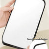 A hand holds a white foldable vanity mirror with smooth rounded edges, showing its design.
