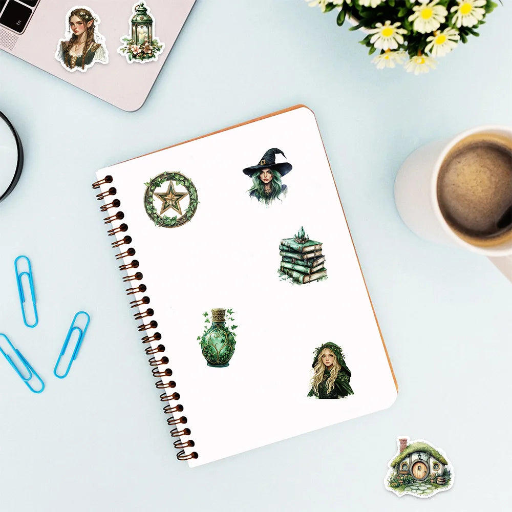 A spiral notebook with decorative stickers featuring a witch theme, including a wreath, a witch figure, and a small house sti