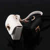 A white and black mini leather openable bag keychain with gold hardware.
