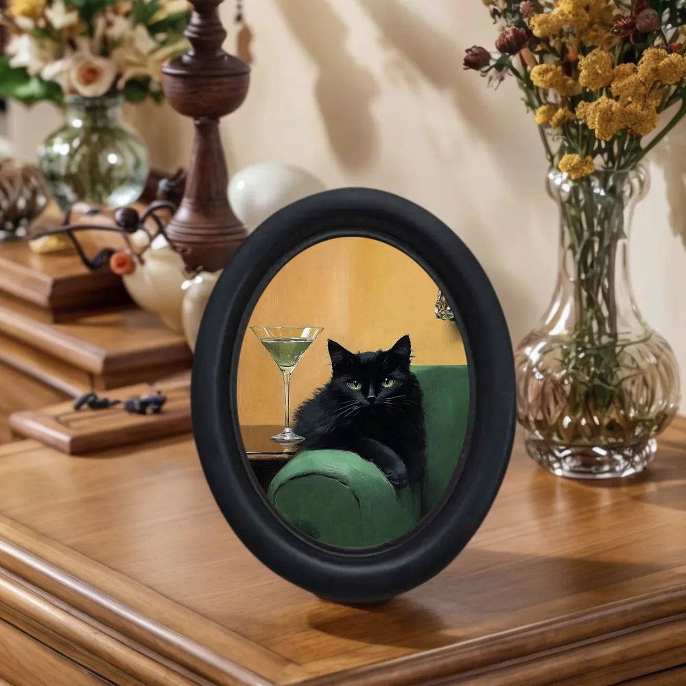 A round black framed mirror art piece featuring a black cat silhouette against a green background.