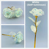 White self-luminous rose flower with green leaves on a gold stem