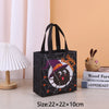 Black non-woven tote bag with a happy Halloween print featuring a bat and spider on a light orange background.